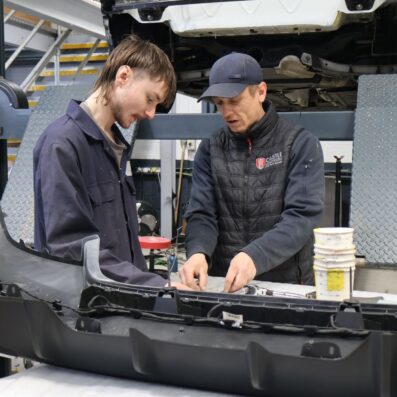 Team working on a vehicle in a bay in the workshop