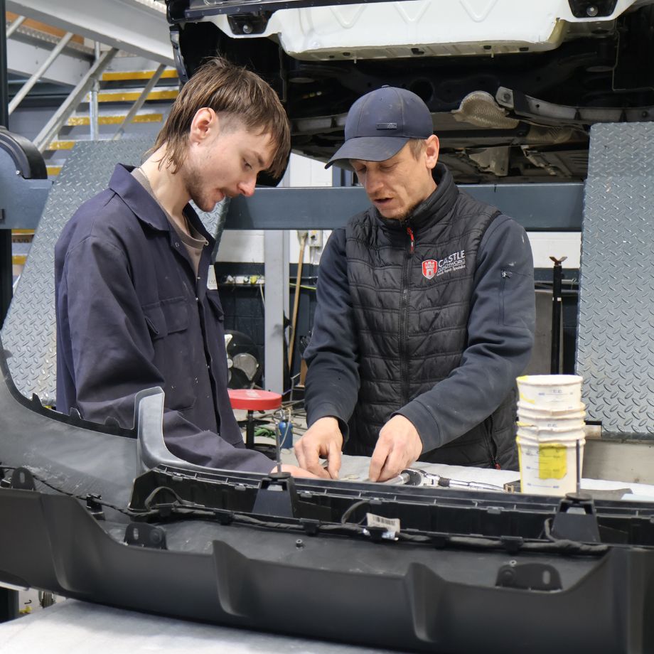 Team working on a vehicle in a bay in the workshop